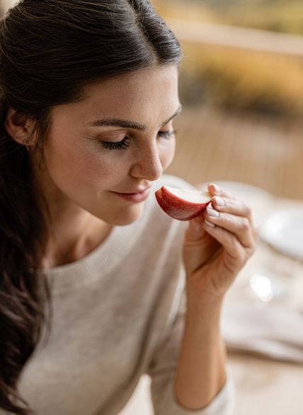 Mujer oliendo una manzana