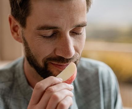Hombre huele una manzana