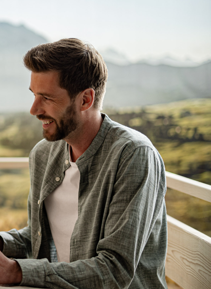 Coppia a un tavolo di legno con mele fresche, sullo sfondo panorama montano